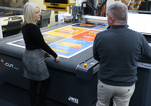 Sue Hayward, CMYUK Commercial Director and Nick Reed, CMYUK Finishing Business Manager, with the JWEI JCUT 1625 digital cutting table.